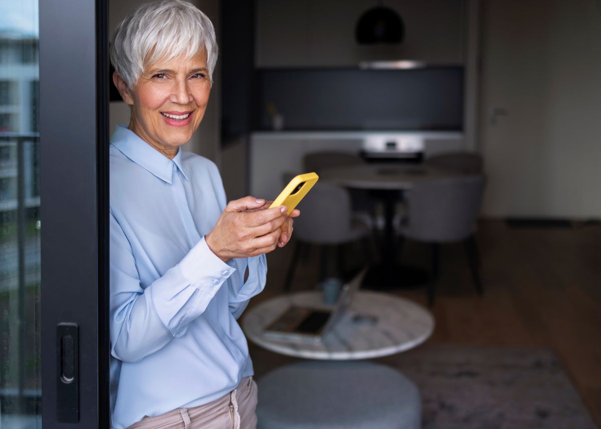 mulher idosa mexendo no celular em casa