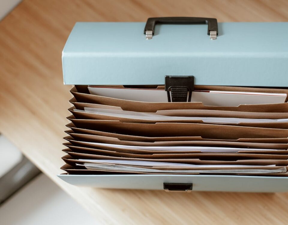 From above of briefcase for documents with papers placed on wooden table in daytime