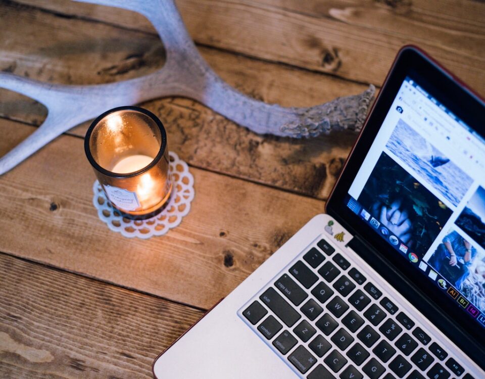 MacBook Pro beside votive candle