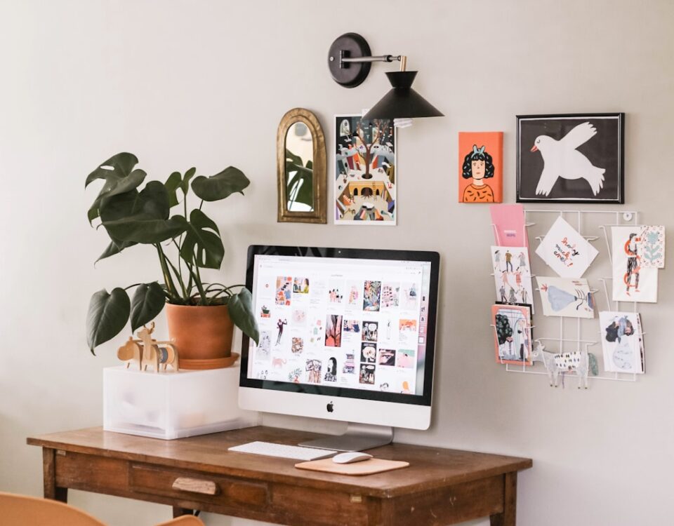 silver iMac on wooden desk