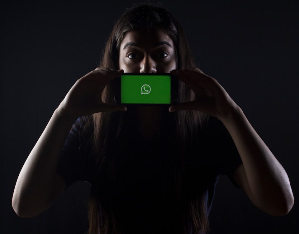 woman holding black smartphone at Whatsapp logo