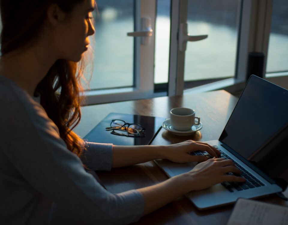 woman sitting beside table using laptop