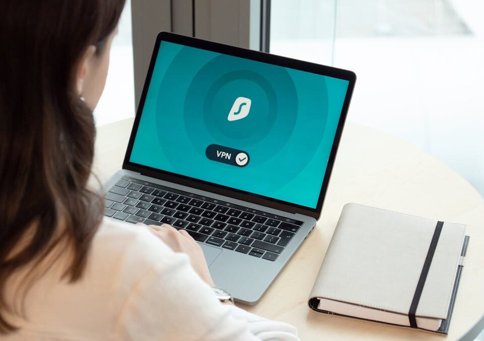 A woman working on a laptop with a VPN icon on screen for secure online browsing.