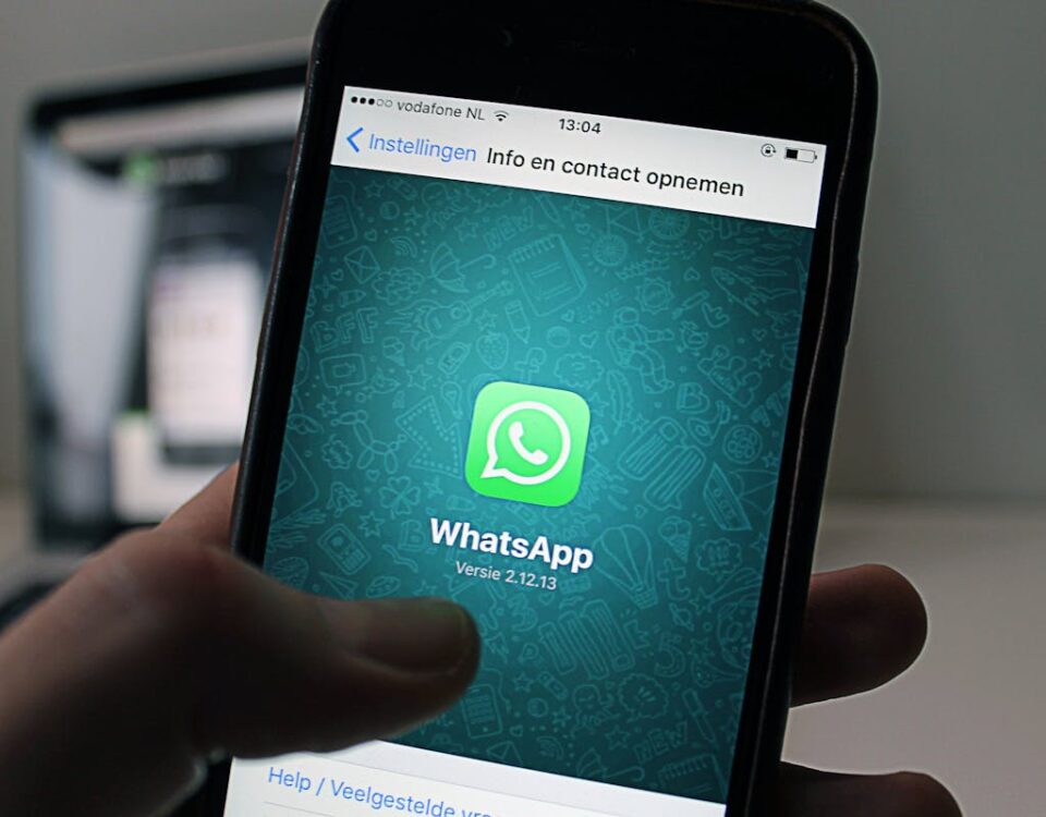 A smartphone displaying the WhatsApp application screen held by a person.