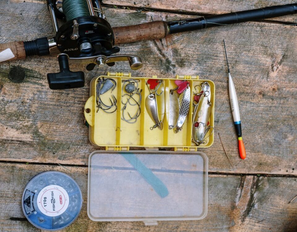 A top-down view of fishing equipment and tackle on a rustic wooden surface.