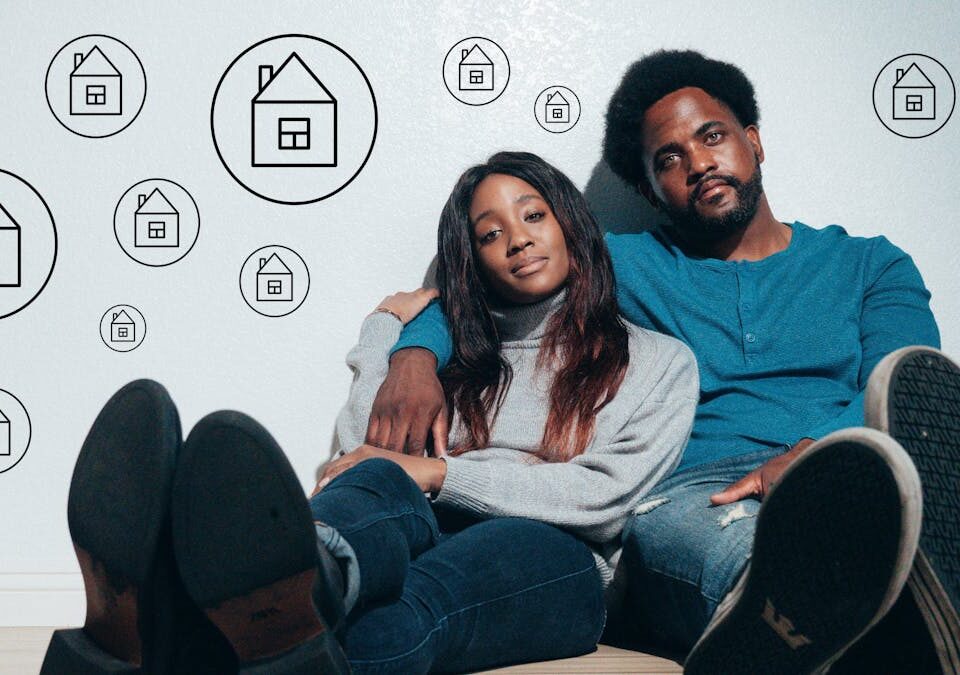 Couple sitting on the floor dreaming about new home ownership surrounded by house icons.