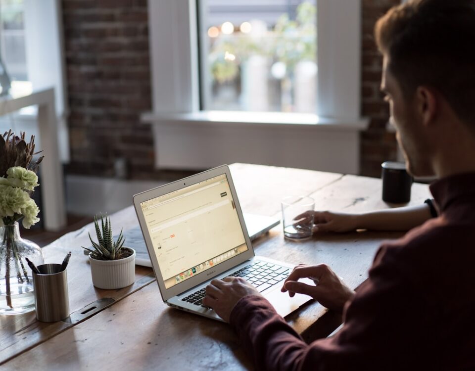 man operating laptop on top of table