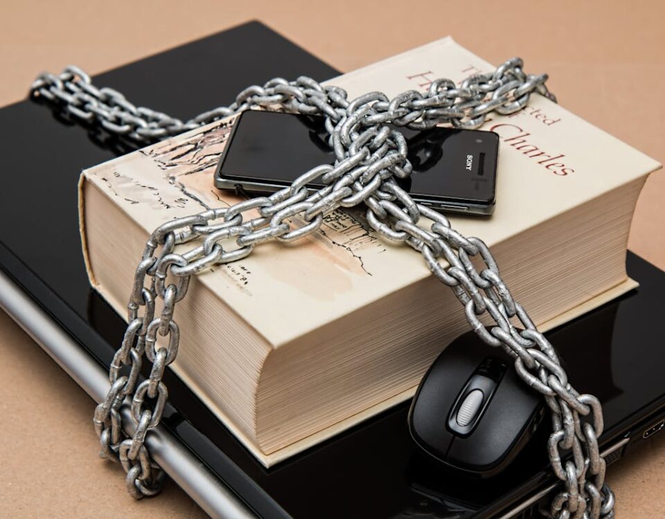 Chain-locked book, phone, and laptop symbolizing digital and intellectual security.