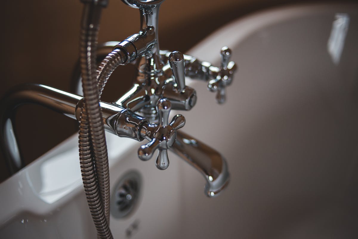 Elegant close-up of a shiny chrome faucet in a modern bathroom setting.