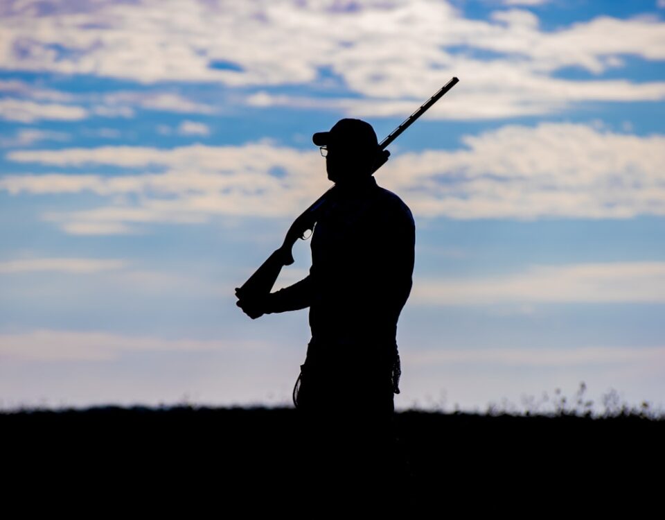 a silhouette of a man holding a gun