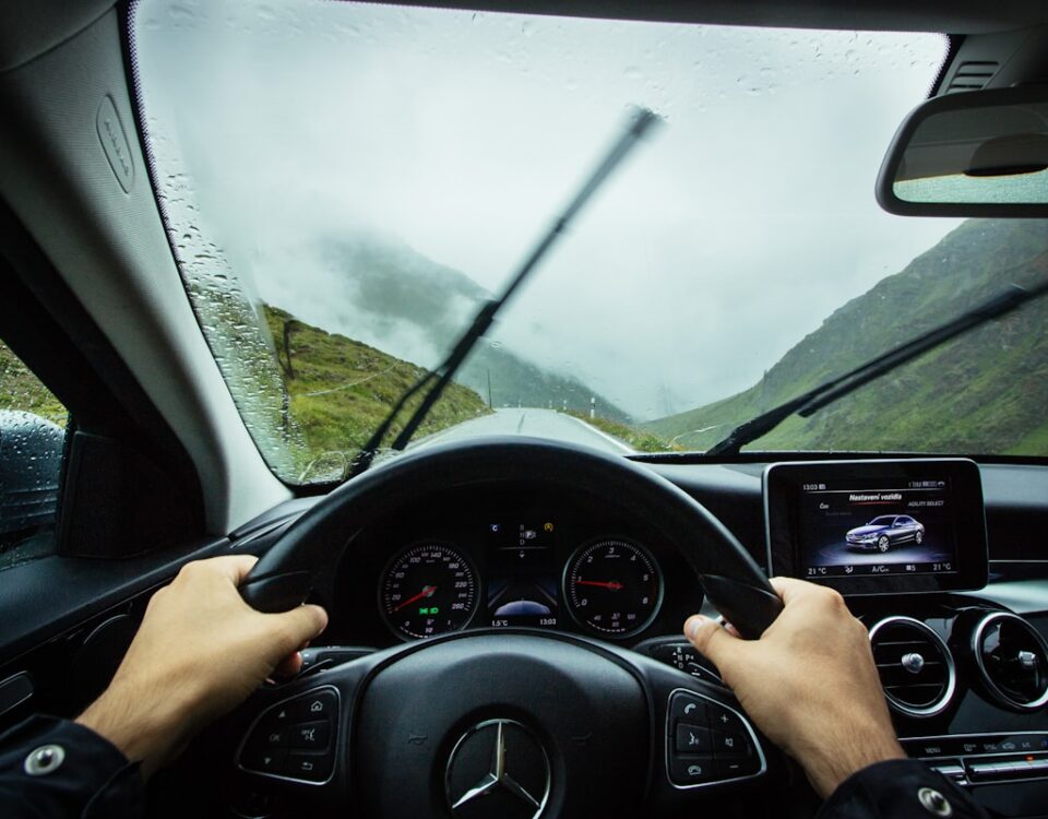 person driving Mercedes-Benz car during daytime