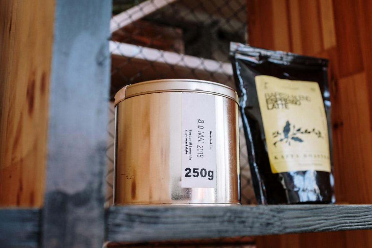 Close-up of coffee products on a wooden shelf, ideal for cafes or loft-style kitchens.