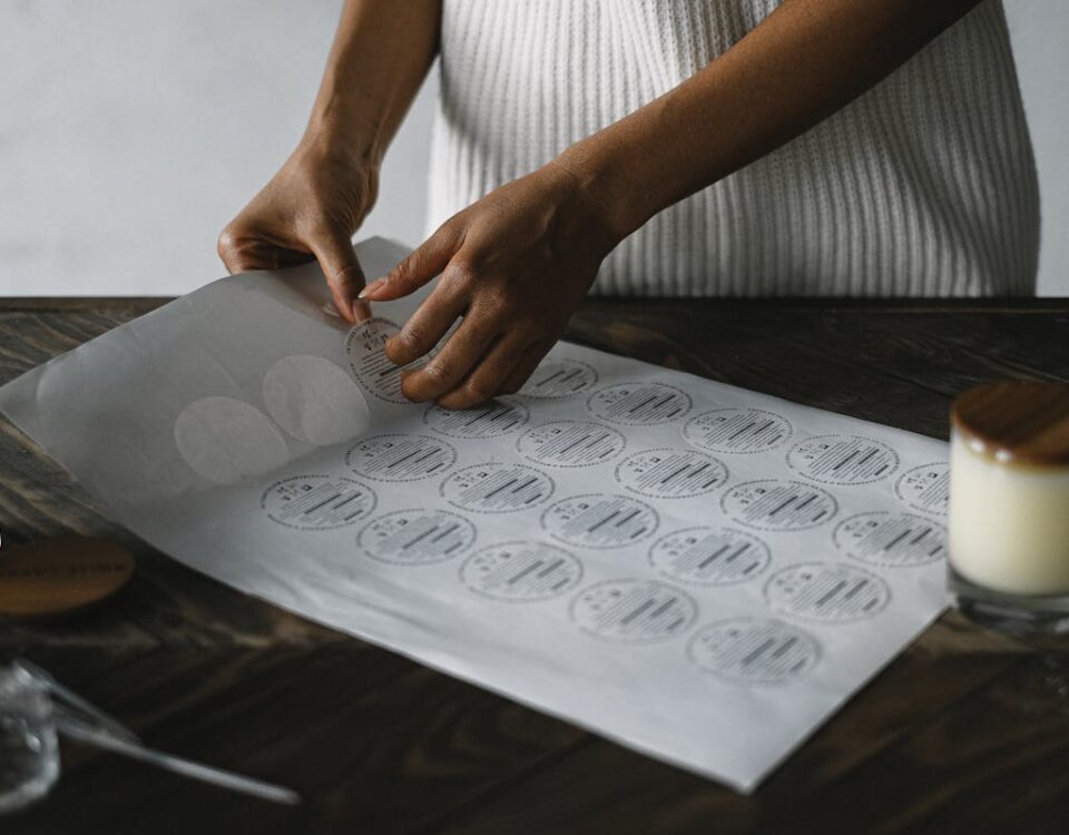 A detail shot of an artisan preparing craft stickers in a cozy workshop setting.